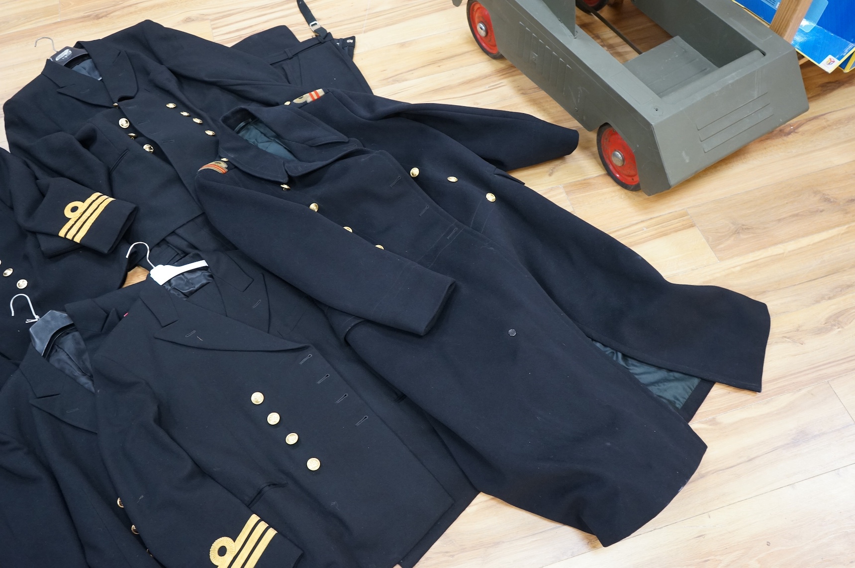 A Royal Navy officer's great coat, cap and four other Navy Officer's jackets. Condition - fair/good